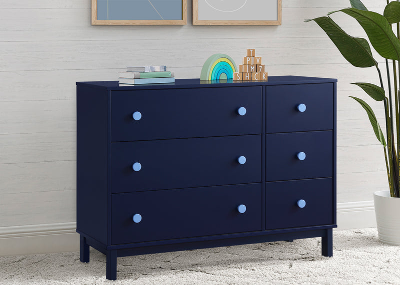 Navy blue dresser with white knobs in a room setting with a plant and framed pictures. 18-babyGap Legacy 6 Drawer Dresser with Interlocking Drawers