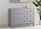 Gray dresser with decorative items against a light gray wall. 24-babyGap Legacy 6 Drawer Dresser with Interlocking Drawers