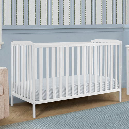 White crib in a room with blue walls and wooden flooring