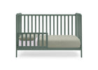 A sage green convertible crib with vertical slats, shown with a mattress and light-colored bedding on a solid white background. 18-Emmie 4-in-1 Convertible Crib