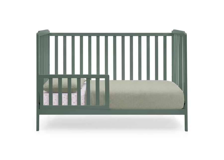 A sage green convertible crib with vertical slats, shown with a mattress and light-colored bedding on a solid white background. 18-Emmie 4-in-1 Convertible Crib