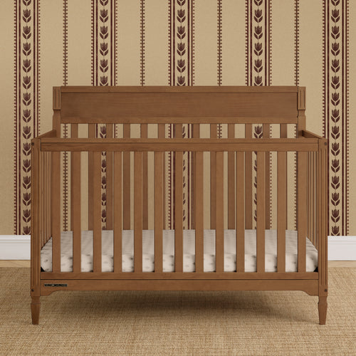 Wooden crib with a striped wall in the background