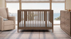 Wooden crib in a room with a view of water and trees 1-Jalen Grow With Me Collection