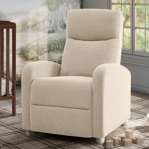 A cream-colored textured fabric recliner chair with rounded arms and a high back, shown in a nursery or playroom setting with a window, rug, and toy blocks.