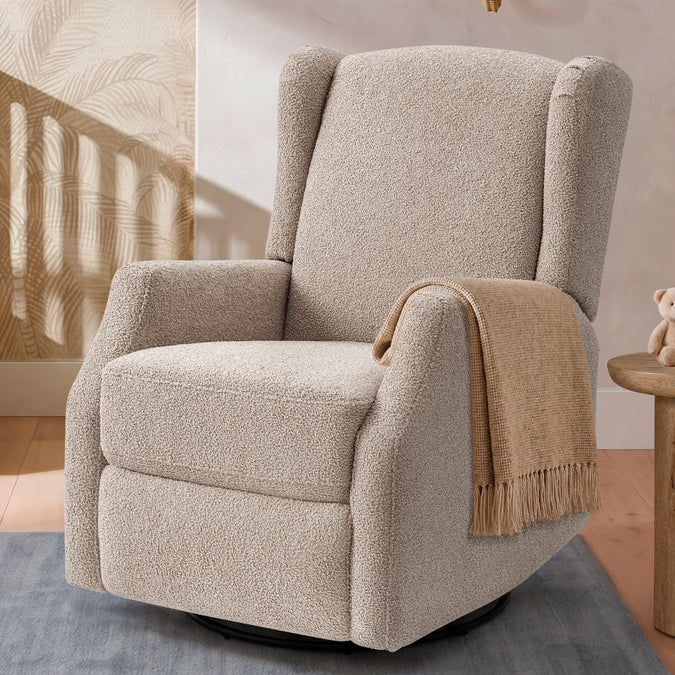 A beige bouclé swivel recliner chair with wingback arms, styled with a tan throw blanket in a warm, modern room setting. 8-James Swivel Recliner
