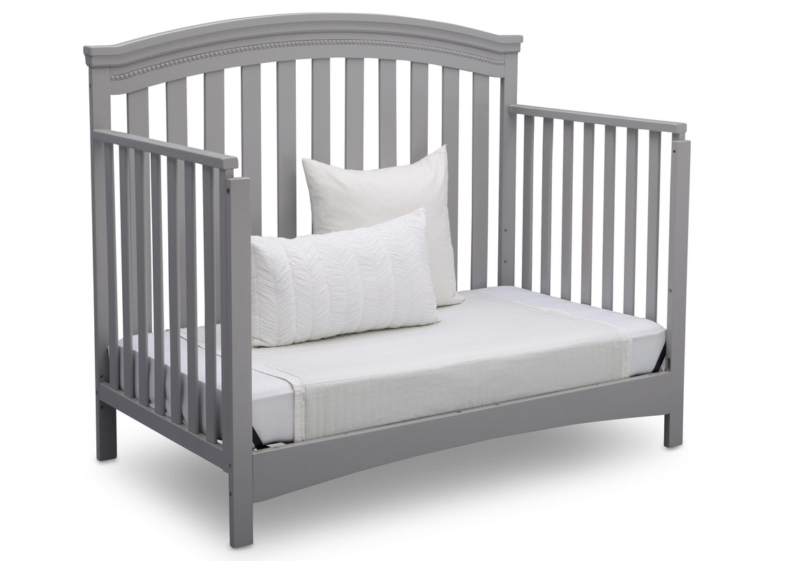 Gray crib with white bedding on a white background