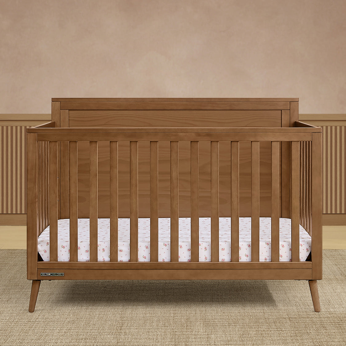 Wooden crib with a beige wall and carpeted floor