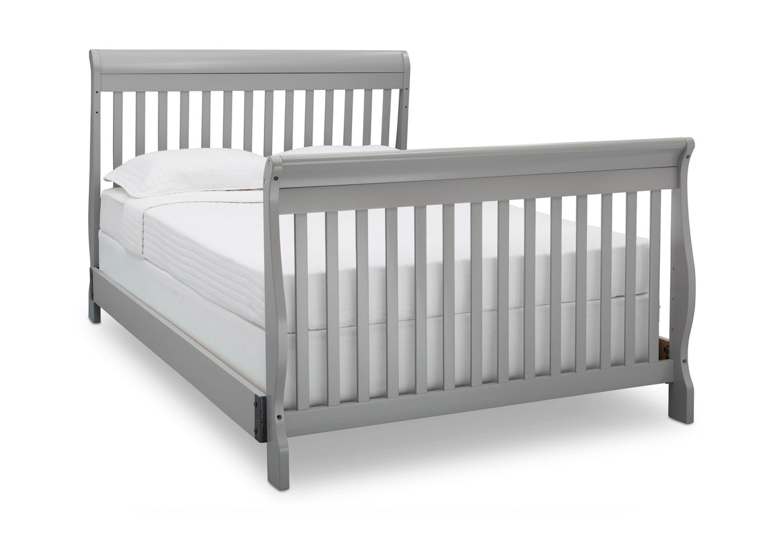 Gray crib with white mattress on a white background