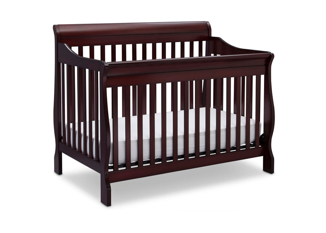 Dark wood crib with white mattress on a white background