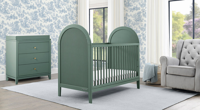 Green crib in a nursery with dresser and armchair. 3-Charlotte Collection