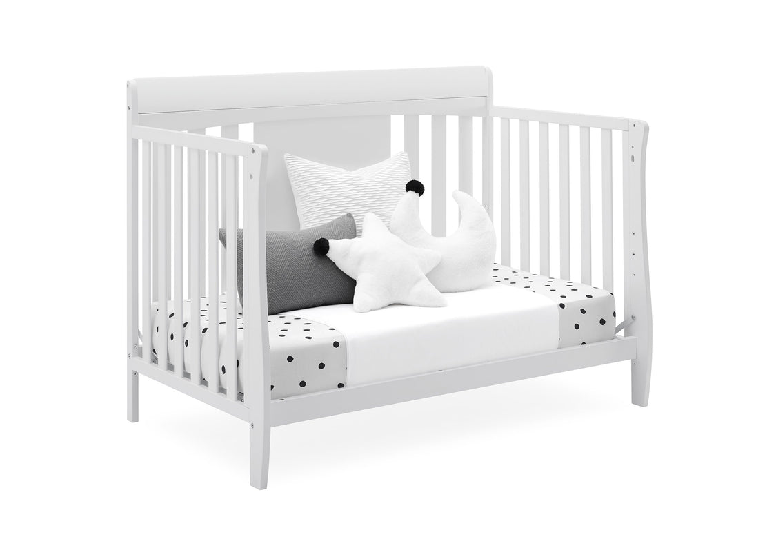 White crib with decorative pillows on a white background