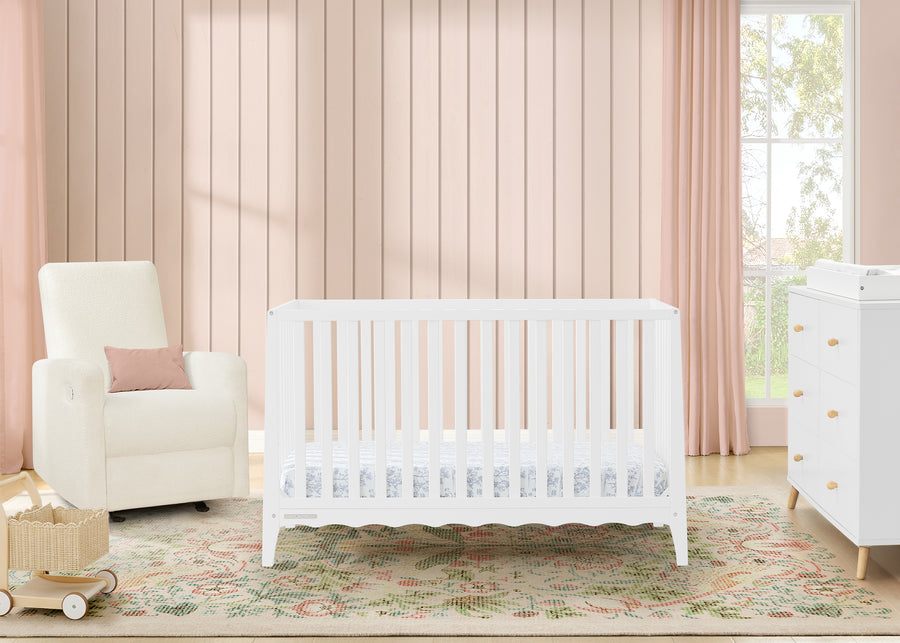 White crib in a nursery with pink walls, chair, and dresser. 15-Lulu 5-in-1 Convertible Crib