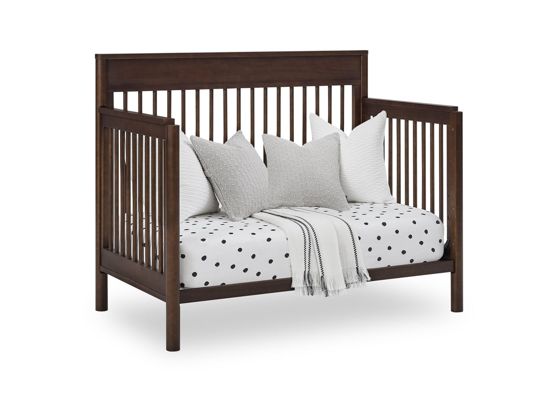 Wooden crib with white bedding and pillows on a white background