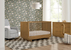 Nursery room with wooden crib, gray armchair, and patterned wallpaper. 27-Rhodes 4-in-1 Convertible Crib