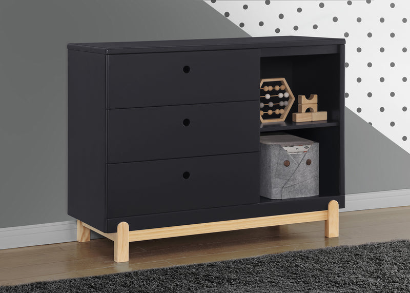 Black dresser with wooden legs in a room with gray walls and a polka dot pattern. 8-Poppy 3 Drawer Dresser with Cubbies