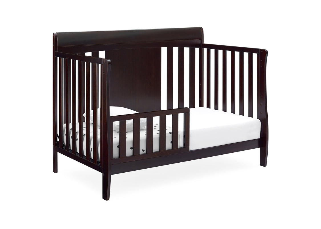 Dark wood crib with white mattress on a white background