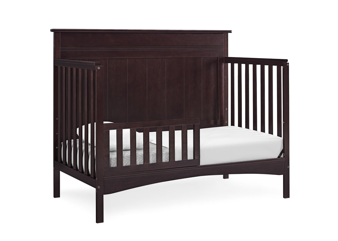 Dark wood crib with white mattress on a white background
