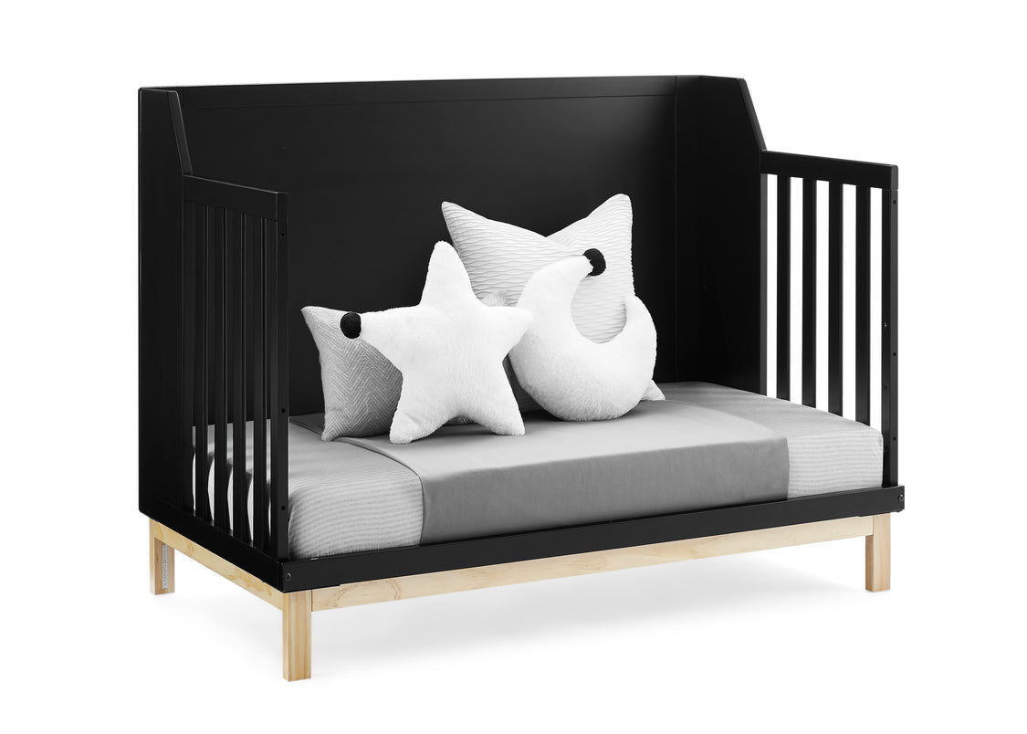 Black crib with white and gray pillows on a white background