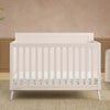 White crib in a room with beige walls and a wooden floor. 26-Lola 6-in-1 Convertible Crib