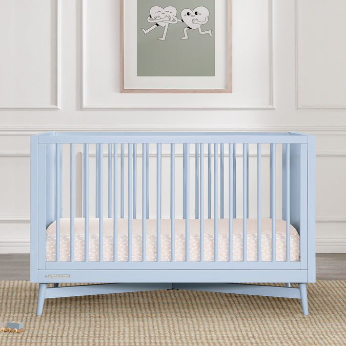 Light blue crib in a room with a framed picture on the wall. 29-Dylan 4-in-1 Convertible Crib