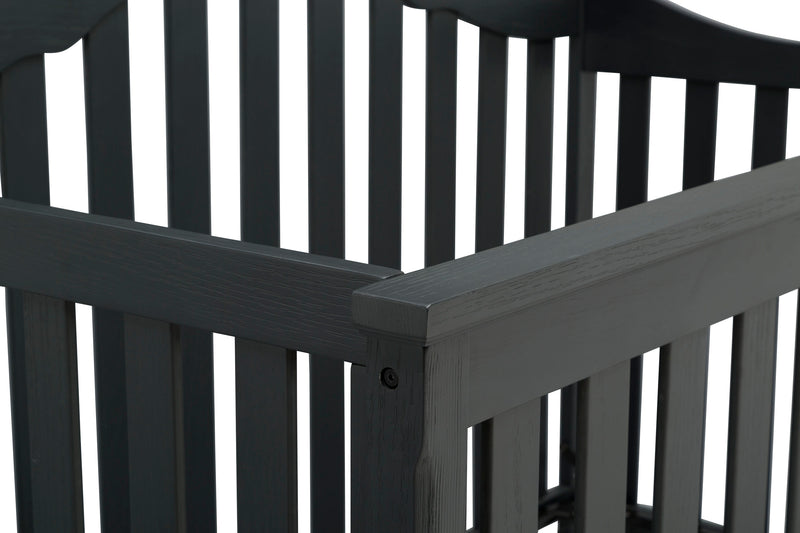 Close-up of a black wooden crib with slatted design.