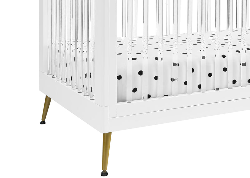 White crib with gold legs and a black and white polka dot fitted sheet. 22-Sloane 4-in-1 Acrylic Convertible Crib