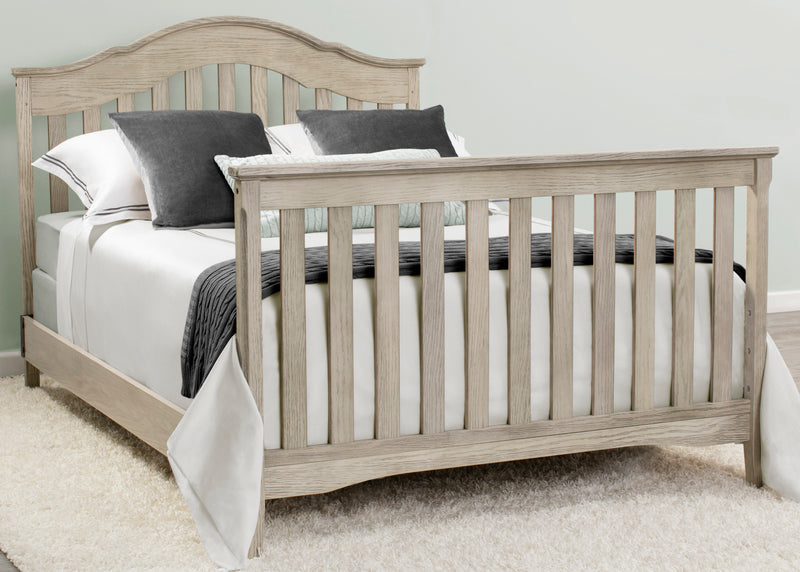 Wooden crib with bedding in a neutral-colored room