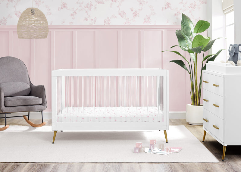 Nursery room with a white crib, gray chair, and pink wall.