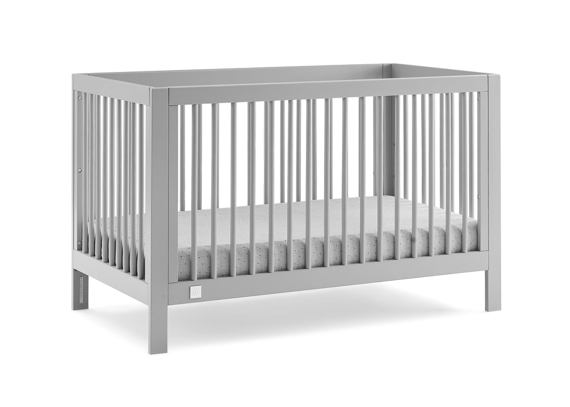 Gray crib with white mattress on a white background