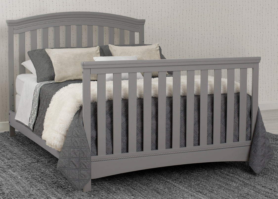 Gray crib with bedding in a room setting