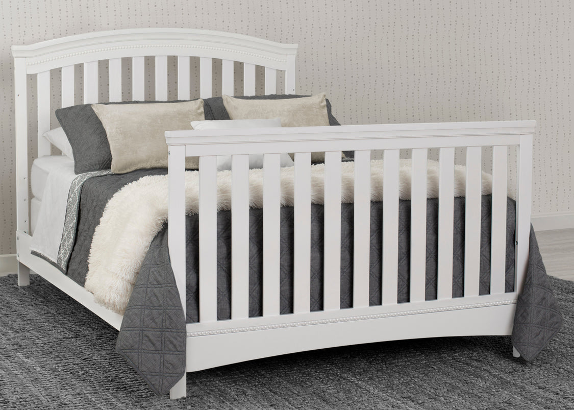 White crib with bedding in a room setting