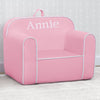Pink children's chair with 'Annie' printed on it against a light gray wall. 8-Personalized Cozee Chair for Kids