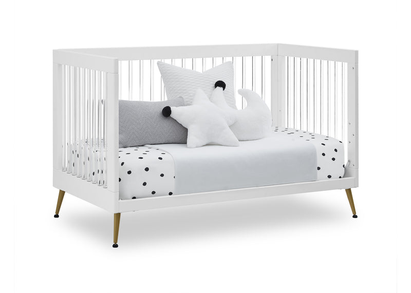 White crib with polka dot bedding and decorative pillows on a white background
