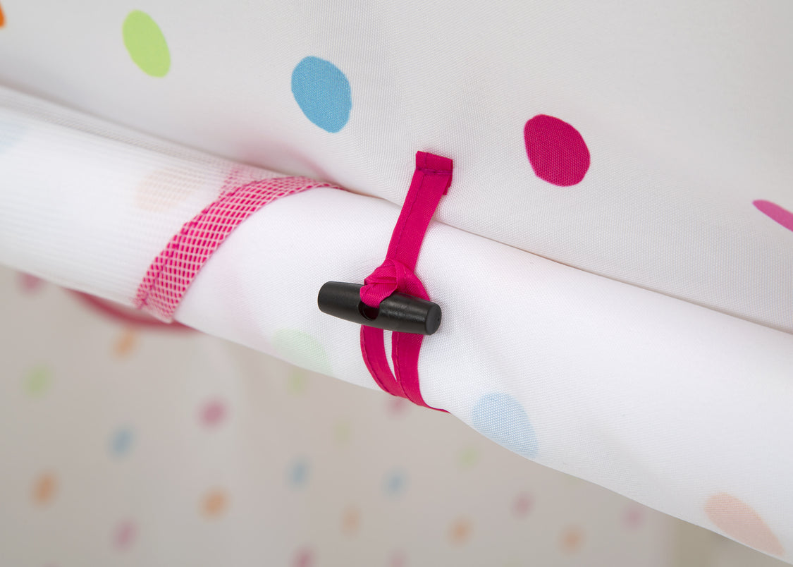 Close-up of a pink strap with a black clip on a polka dot background