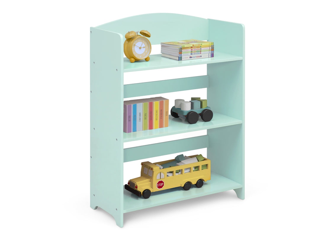 A three-tier wooden toy bookshelf in mint green, styled with children's toys including a yellow alarm clock, books, a toy train, and a toy school bus, on a white background.