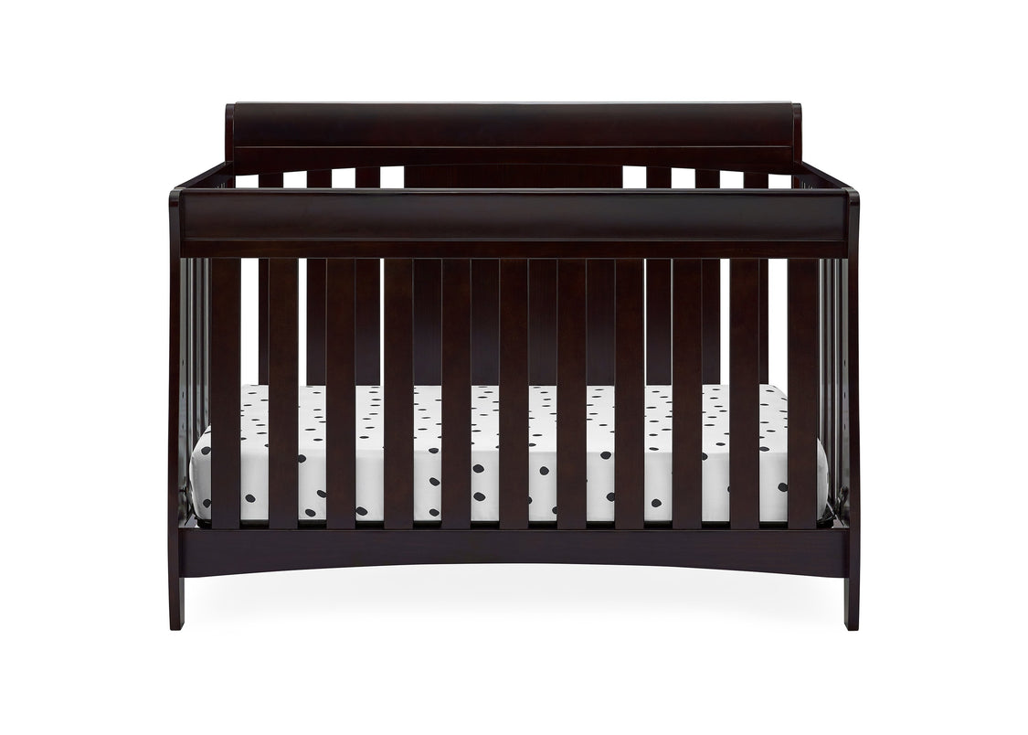 Dark wood crib with white bedding on a white background