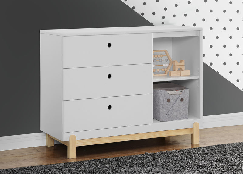White dresser with wooden legs against a gray wall with a polka dot pattern. 13-Poppy 3 Drawer Dresser with Cubbies