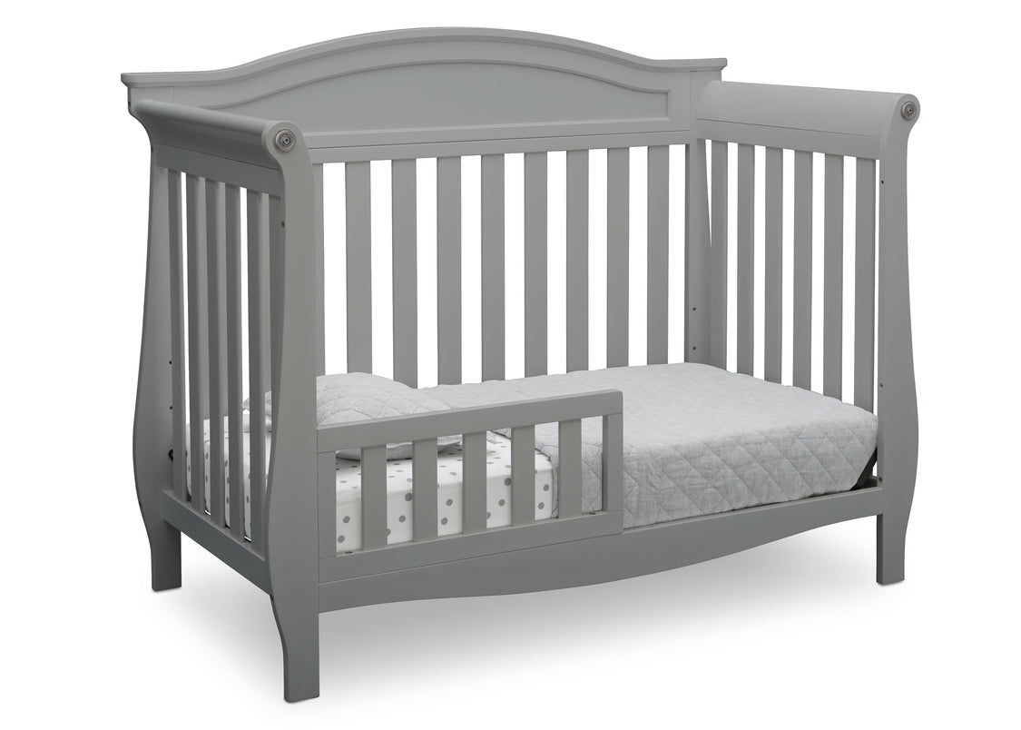 Gray crib with a mattress on a white background