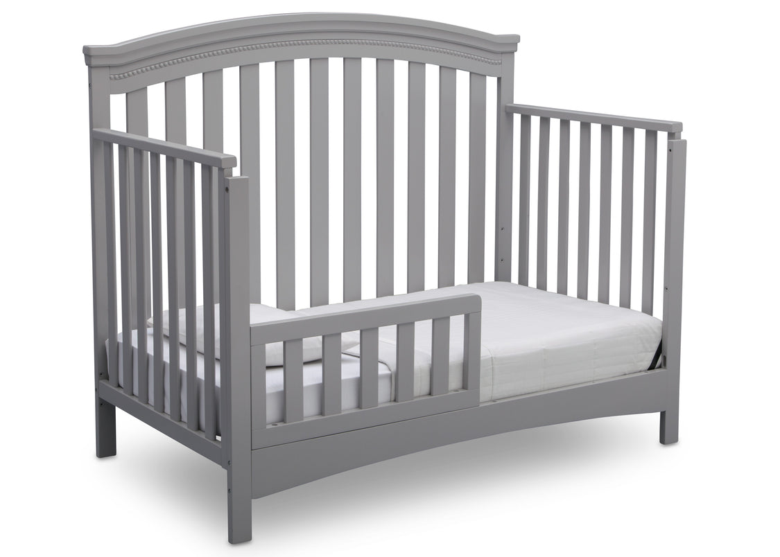 Gray crib with a white mattress on a white background