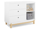 White dresser with wooden legs and open shelf containing a gray basket and wooden blocks on a white background 14-Poppy 3 Drawer Dresser with Cubbies