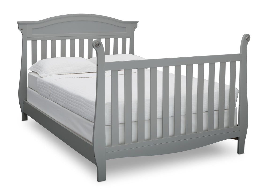 Gray crib with white mattress on a white background