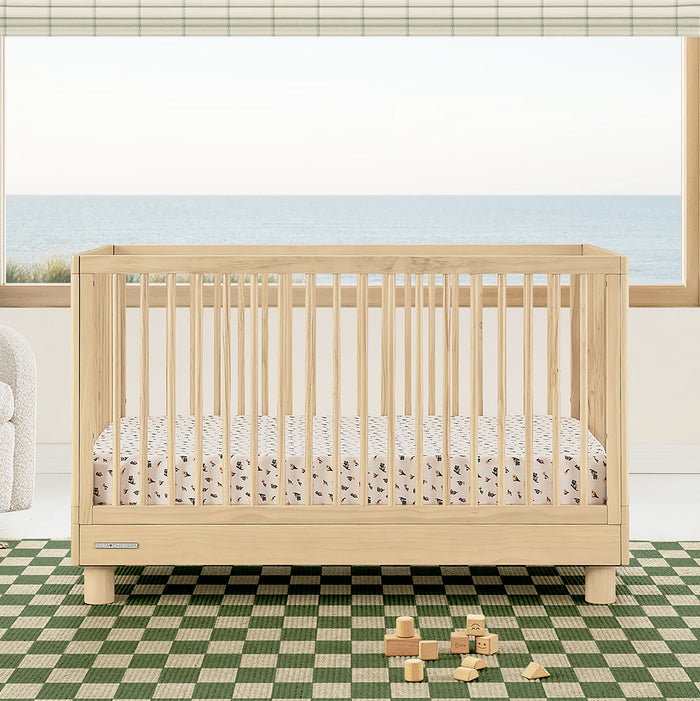 Wooden crib with a checkered floor and wooden blocks in a room with large windows. 0-Ari 4-in-1 Convertible Crib