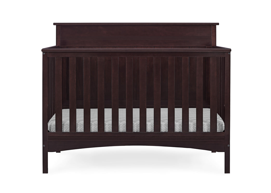 Dark wood crib with striped mattress on a white background