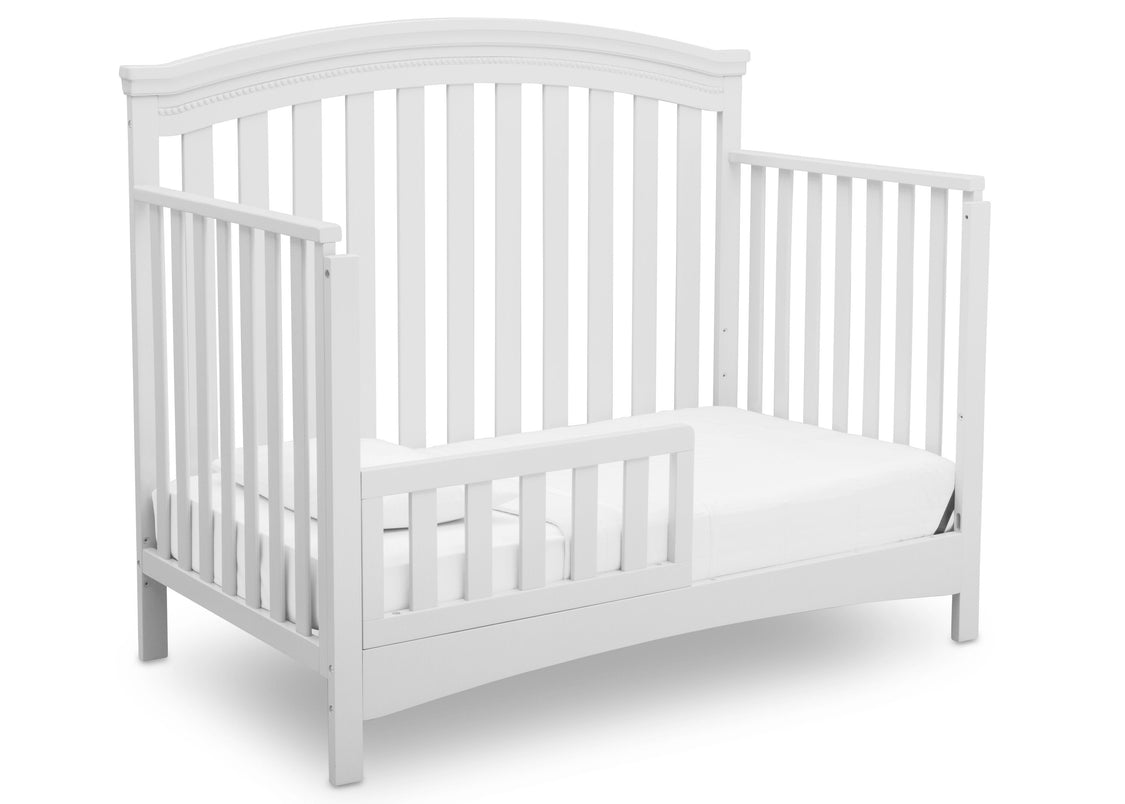 White crib with a mattress on a white background