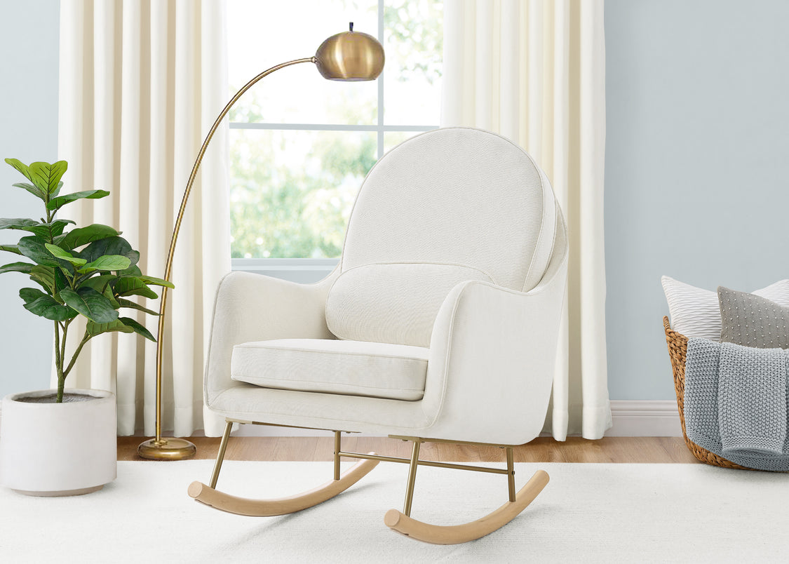White rocking chair in a room with a plant, lamp, and basket.
