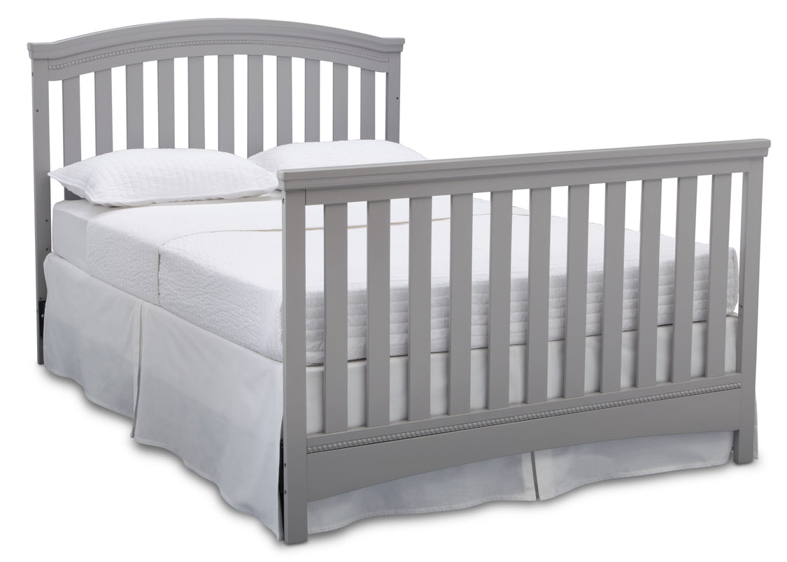 Gray crib with white bedding on a white background