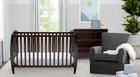 Nursery room with dark wood crib, gray chair, and dresser. 10-Taylor 4-in-1 Convertible Crib