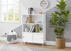 White bookshelf with decorative items in a room with a plant and clock on the wall. 14-Essex Bookcase