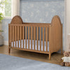 Wooden crib in a nursery with floral wallpaper and a teddy bear. 30-Willa 4-in-1 Convertible Crib