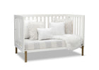 White crib with wooden legs, white bedding, and gray and white striped blanket on a white background 22-Hendrix 4-in-1 Convertible Crib
